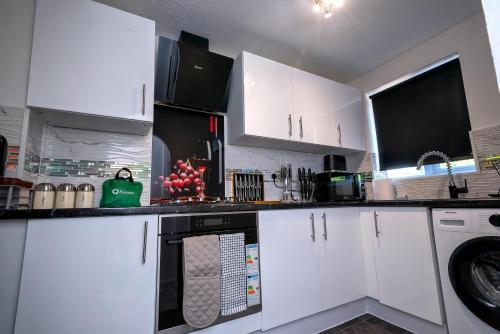 a kitchen with white cabinets and a dishwasher at I Love London! A Stunning 2 Bed Home Sleeps 1-3! in London