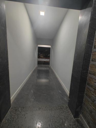 an empty hallway with white walls and a tile floor at JP Residency, near to Isha, Adhiyogi & Karunya in Alāndurai