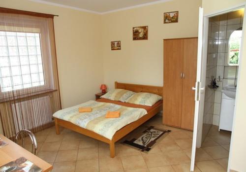 a small bedroom with a bed and a bathroom at Lorens Family in Mikołajki