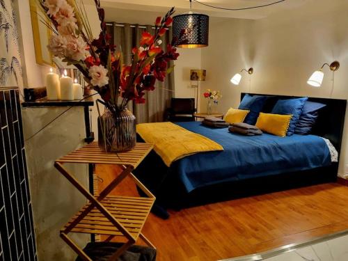 - une chambre avec un lit bleu et un vase de fleurs dans l'établissement Romantique room St Michel de Lanes (love room), à Saint-Michel-de-Lanès