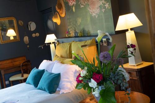 a bedroom with a bed with flowers on it at L'école des garçons in Maigné