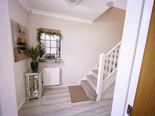 a white staircase in a home with a potted plant at Entire 3-Bedroom Home in Oldham - Guest house in Oldham