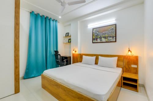 a bedroom with a bed and a blue curtain at Premium 2bhk near Airport, Manipal Hospital, Venkatesh Hospital and Yashobhoomi Convention Centre in New Delhi