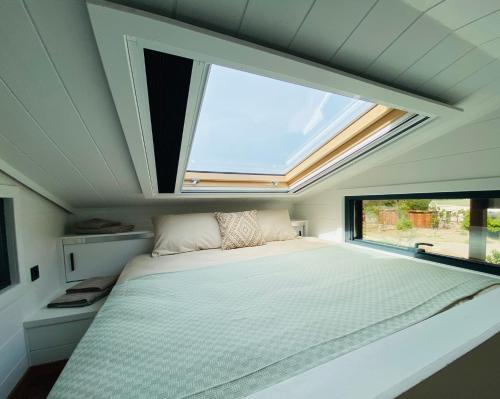 sypialnia z łóżkiem i dużym oknem w obiekcie Natural Garden Tiny House Yalikavak w mieście Yalıkavak