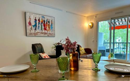 - une table à manger avec des assiettes et des vases dans l'établissement Le Victor Hugo de la Robine, à Narbonne