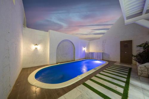 una piscina in una stanza con soffitto di شاليهات شاطىء غروب الشمس لبيوت العطلات a Jazan