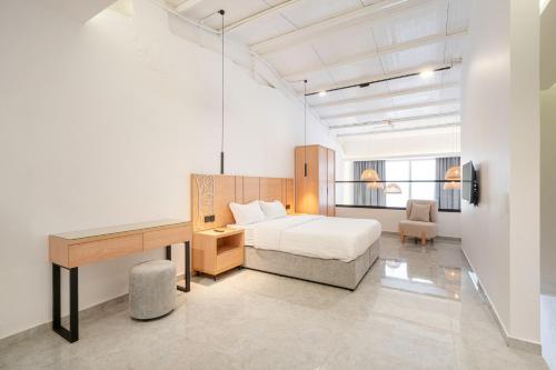 a bedroom with a bed and a desk in a room at شركة شاطىء غروب الشمس لبيوت العطلات in Jazan