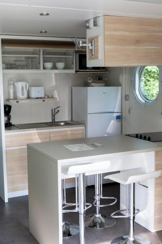 une cuisine avec un îlot blanc dans l'établissement Camping touristique de Gien, à Poilly-lez-Gien