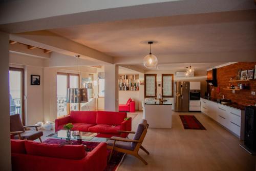 a living room with a red couch and a kitchen at Villa Norvegia in Ohrid