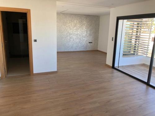an empty room with a wooden floor and a mirror at La Fondation in El Harhoura