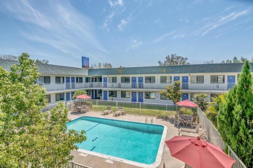 an overhead view of a hotel with a swimming pool and umbrellas at Motel 6-Tracy, CA in Tracy