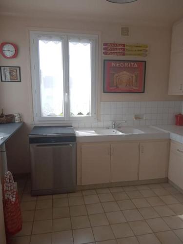 une cuisine avec un évier et une fenêtre dans l'établissement Le Vintage 14, à Bayeux