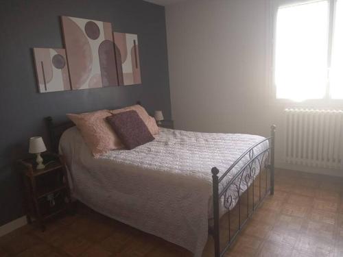 a bedroom with a bed and a window at Le Vintage 14 in Bayeux