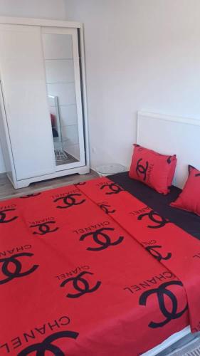 Un dormitorio con una manta roja con serpientes negras. en Fernand ville oran, en Orán