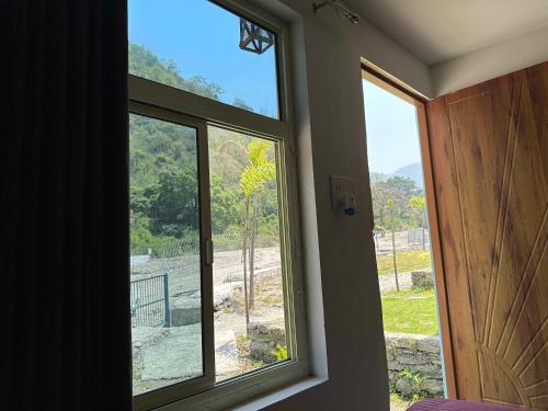 a window in a room with a view of a yard at Shivanjal River Resort in Bijni