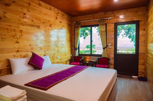 a bedroom with a bed and a wooden wall at Tam Coc Moutainside Homestay in Ninh Binh