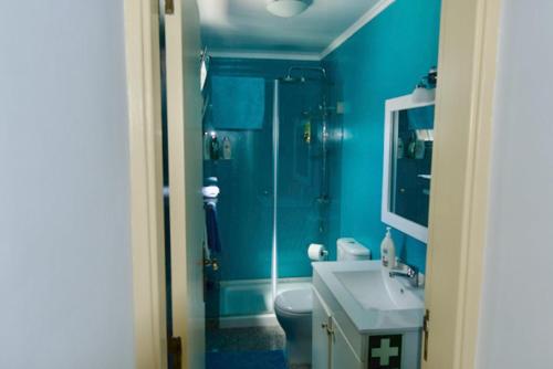Baño azul con aseo y lavamanos en O sexto en Sintra