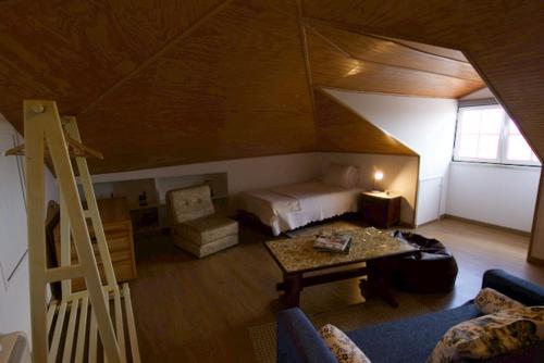 a attic room with a bed and a table at O sexto in Sintra