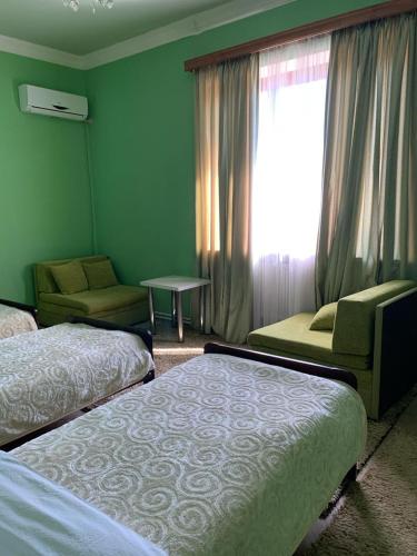 a hotel room with two beds and a window at Hotel Villa DavidL in Sagarejo