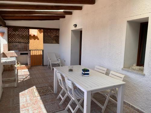 einen weißen Tisch und Stühle auf einer Terrasse in der Unterkunft Perla marina House in Santa Teresa Gallura