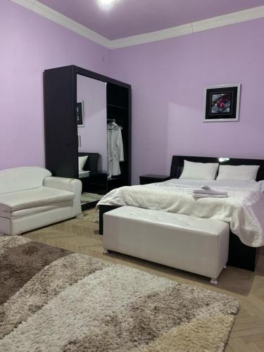 a bedroom with a bed and a chair and a mirror at Hotel Villa DavidL in Sagarejo