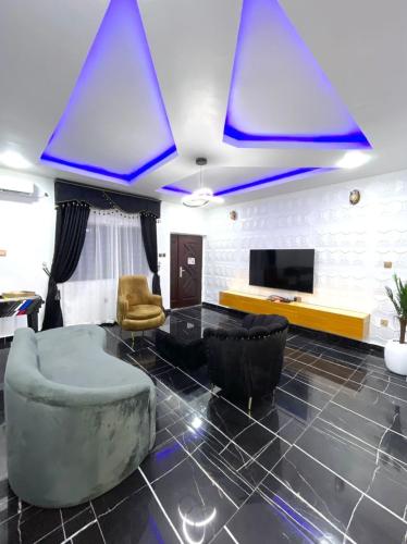 ein Wohnzimmer mit blauen Lichtern an der Decke in der Unterkunft CEO HOMES AND APARTMENT in Warri