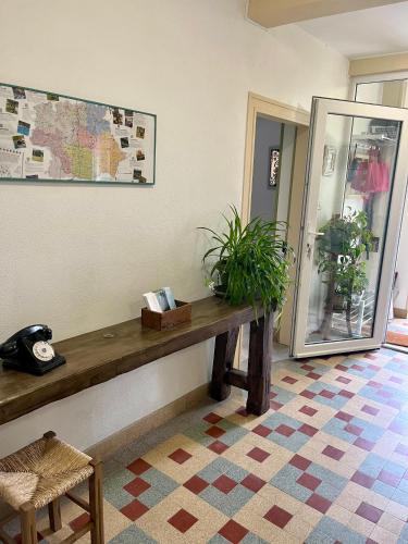 a room with a wooden table and plants on a wall at Gîte Ensemont in Saramon