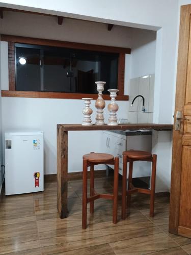 uma cozinha com uma mesa de madeira e 2 bancos em Chalé Torneados em Tiradentes
