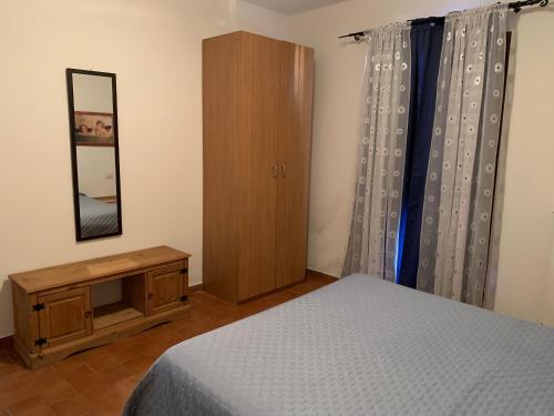 Schlafzimmer mit einem Bett, einer Kommode und einem Spiegel in der Unterkunft Perla marina House in Santa Teresa Gallura