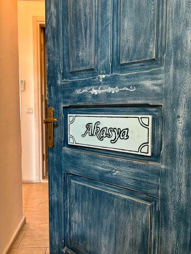 a blue wooden door with a sign on it at Alacati Zeynep Otel in Alacati