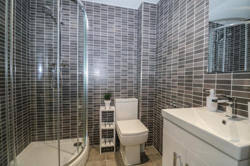 y baño con aseo, ducha y lavamanos. en The Secret Cottage 5A, en Seaford
