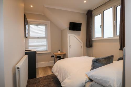 1 dormitorio con 1 cama, TV y ventanas en 6, The Cuckmere, en Seaford