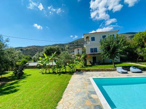 a villa with a swimming pool and a house at Cottage with private boat & pool in Poros