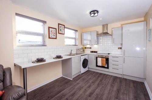 uma cozinha com um balcão branco e um lavatório em Two Bedroom Luxury RB Home em Stalybridge