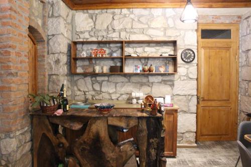 a kitchen with a stone wall with a wooden table at Royal Edena in Ambrolauri