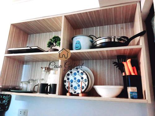 a kitchen shelf with a bunch of pots and pans at Casa Gabriel in Marilao in Marilao