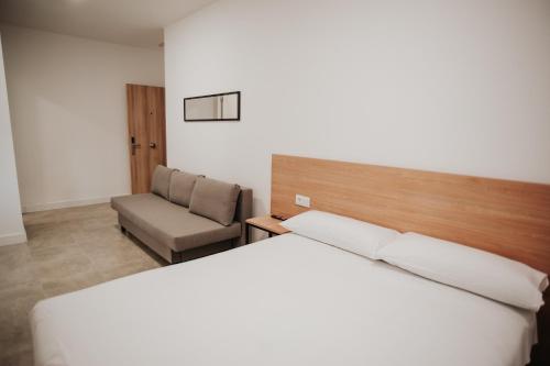 Zaratán的住宿－Polorooms，配有一张床和一把椅子的酒店客房