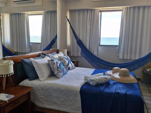 ein Schlafzimmer mit einer Hängematte und einem Hut darauf in der Unterkunft Recanto Maravista apto Frente Mar 2 quartos in Vila Velha