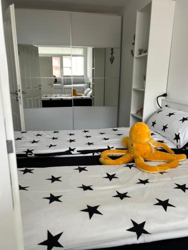 a teddy bear laying on a bed with black stars at Frische Brise Ferienwohnung mit Meerblick in Cuxhaven