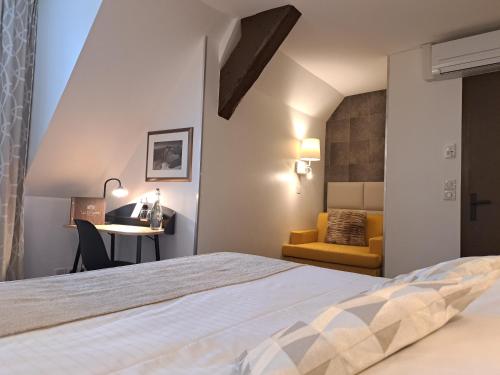 a bedroom with a bed and a desk and a chair at Hôtel des Princes, Chambéry Centre in Chambéry