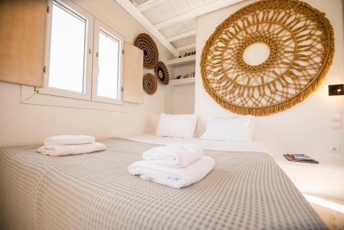a bedroom with two towels on a bed with a mirror at Villa Poppy private pool by opus in Mikonos