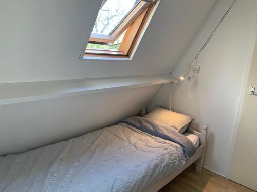 a small bed in a small room with a window at Heerlijk vakantiehuis in bos bij Durbuy in Durbuy