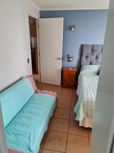 uma sala de estar com duas camas e uma mesa com um candeeiro em Costa azul 1 em Iquique