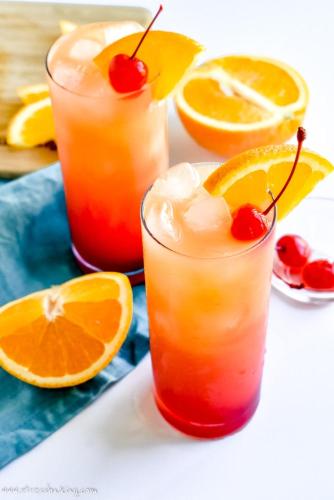 dois cocktails com laranjas e cerejas numa mesa em Hotel Noppytalk em Hambantota