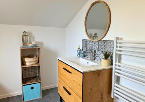 La salle de bains est pourvue d'un lavabo et d'un miroir. dans l'établissement Chalet Paisible proche du Lac, à Biscarrosse
