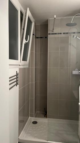 une salle de bain avec une douche avec une porte vitrée dans l'établissement Studio indépendant cœur Paris 13ème, à Paris