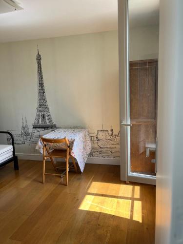 une chambre avec une table et la tour Eiffel dans l'établissement Studio indépendant cœur Paris 13ème, à Paris