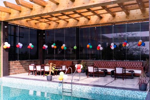a patio with a pool and some chairs and balloons at The Autograph Inn in Siliguri