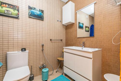 ein Badezimmer mit einem Waschbecken, einem WC und einem Spiegel in der Unterkunft Vibing & Liming Ericeira in Ericeira