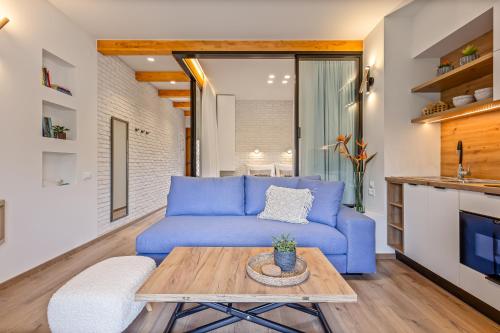 a living room with a blue couch and a table at Lola Apartments in Liapades